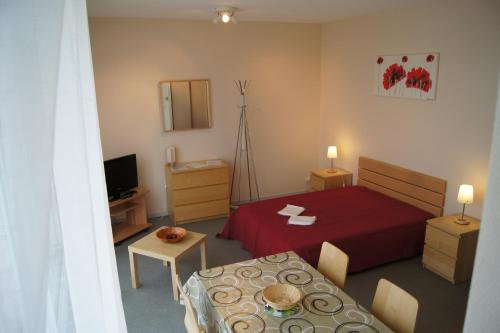 - une petite chambre avec un lit rouge et une table dans l'établissement Thermes & Vacances Residence ATLANTICA, à Rochefort