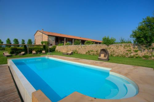 una piscina en un patio con una casa en Relais Corte Guastalla Apartments, en Sona