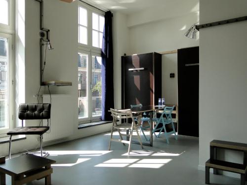 a room with a table and chairs in it at LABnul50 self check-in hotel Groningen in Groningen