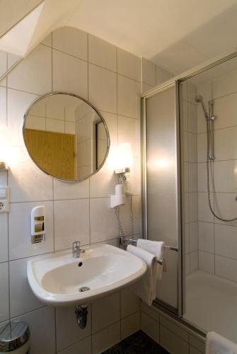 a bathroom with a sink and a shower and a mirror at Hotel Sonneck in Schwäbisch Hall