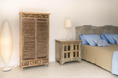 ein Schlafzimmer mit einem Bett und einem Holzschrank daneben in der Unterkunft Marietaland in Campos