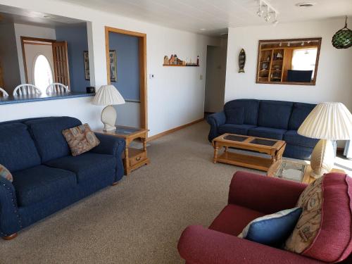 a living room with two blue couches and a table at Algoma Beach Motel in Algoma