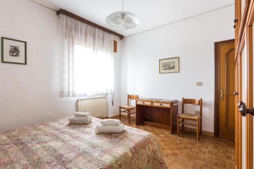 Schlafzimmer mit einem Bett, einem Schreibtisch und einem Fenster in der Unterkunft Home Near Venice in Favaro Veneto