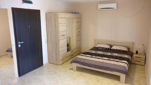 een slaapkamer met een bed en een kast erin bij Club Priz in Primorsko