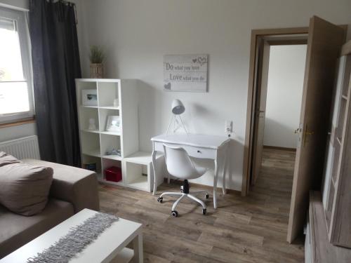 a living room with a desk and a chair at Ferienwohnung Anke - Apartment 5d in Heinsberg