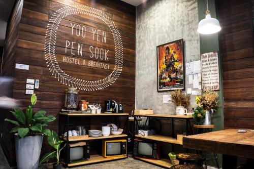 a restaurant with wooden walls and a sign on the wall at Yoo Yen Pen Sook in Bangkok