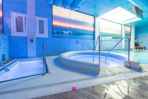 a large bathroom with a tub and a swimming pool at Hotel Norat Marina & Spa 4* Superior in O Grove