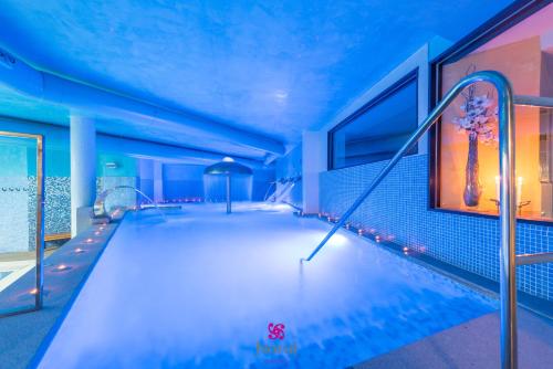 una piscina con iluminación azul en un edificio en Hotel Norat Marina & Spa 4* Superior en O Grove