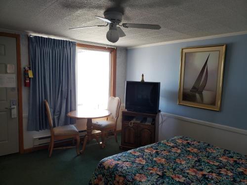 a hotel room with a bed and a table and a television at Algoma Beach Motel in Algoma