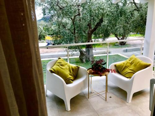 a balcony with two chairs and a window with a tree at Agriturismo Giorgio in Mattinata