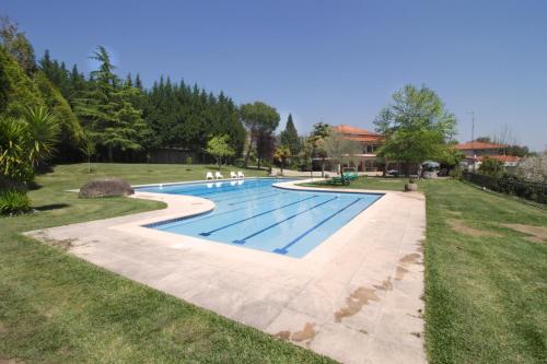 a swimming pool in a yard with grass at Casa do Lago in Amares