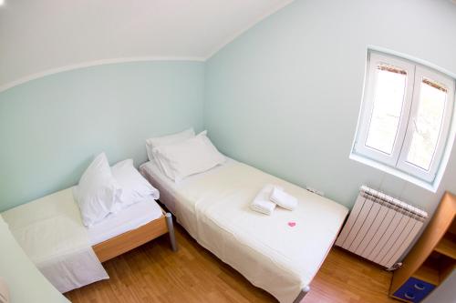 a small bedroom with two beds and a window at Apartments Golden View in Kotor