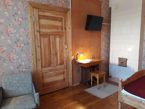 a room with a wooden door and a desk and a bed at Centra apartamenti in Jēkabpils
