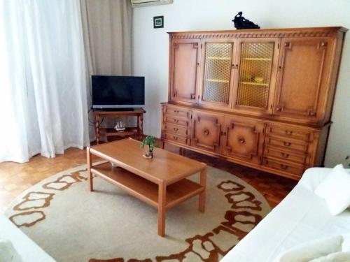 a living room with a coffee table and a tv at Apartman Maria in Crikvenica
