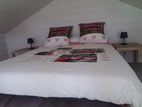 un lit blanc avec deux oreillers dessus dans l'établissement Petit Chalet Chez Marcelline, à Amécourt