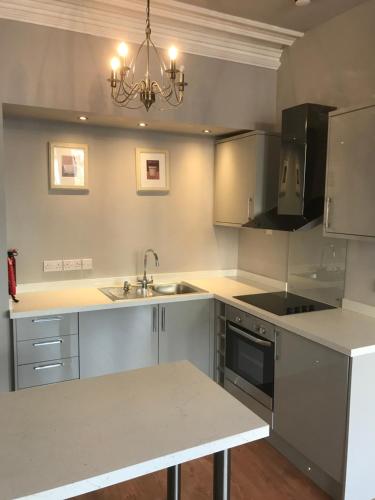 a kitchen with a sink and a stove at 7 Llewelyn Avenue in Llandudno