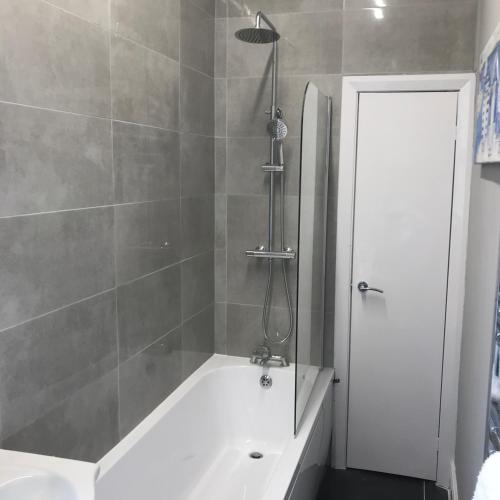 a bathroom with a shower and a bath tub at 7 Llewelyn Avenue in Llandudno
