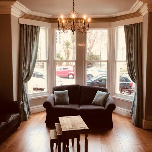 a living room with a couch and large windows at 7 Llewelyn Avenue in Llandudno
