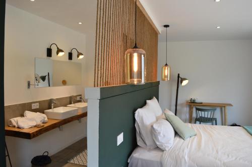 a bedroom with a bed and a bathroom with a sink at Les Petites Maisons in Sotta