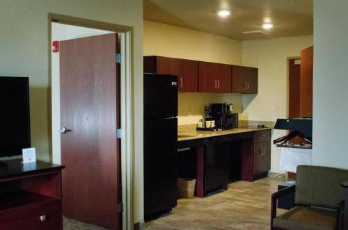 a kitchen with a black refrigerator and a counter top at Cobblestone Inn & Suites - Soda Springs in Soda Springs