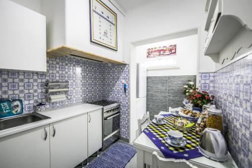 uma pequena cozinha com azulejos azuis e brancos em Dream City Home nas Caldas da Rainha
