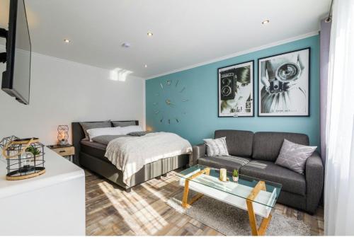 a living room with a couch and a bed at Gemütliches Apartment bei Leipzig - ideal für Urlauber & Geschäftsreisende in Neukieritzsch