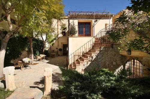 a building with a staircase and a building with trees at Sa Bisbal - Turismo de interior in Selva