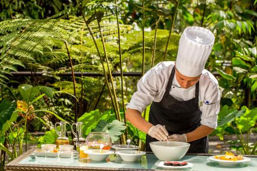 a man in a chefs hat preparing food on a table at Mashpi Lodge in Pacto
