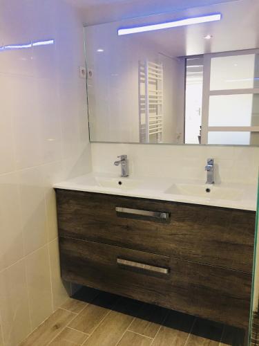 une salle de bain avec un lavabo et un miroir dans l'établissement Au Bord de La Dhuy, à Orges