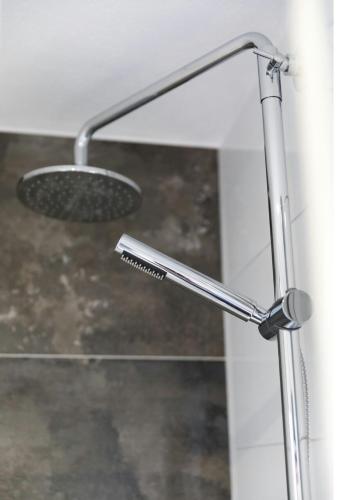 a shower with a shower head in a bathroom at Gemütliches Apartment bei Leipzig - ideal für Urlauber & Geschäftsreisende in Neukieritzsch