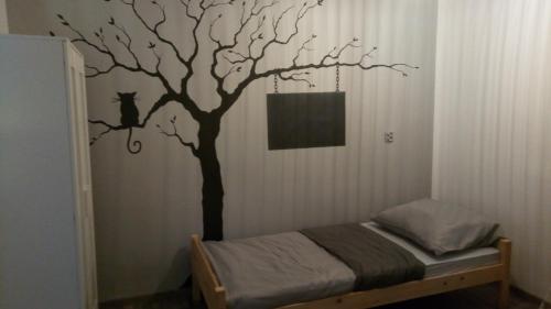 a bedroom with a tree and a cat on the wall at Folwark Anna in Kamienica Polska