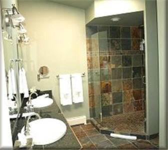 a bathroom with two sinks and a shower at A View of the Lake B & B in West Kelowna