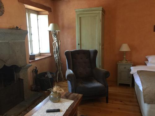 a bedroom with a chair and a bed and a fireplace at Artsistas Houses in Aristi