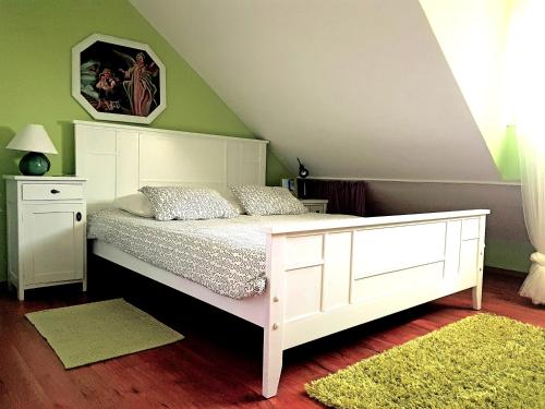 a bedroom with a white bed and a green wall at Apartment Silvia in Kaštela