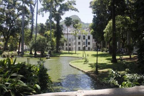 a building in a park with a river and trees at Hostel Flamengo in Rio de Janeiro