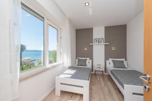 Duas camas num quarto com vista para o oceano em Portos Apartment em Zadar