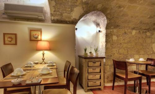 a dining room with a table and chairs and a stone wall at Hotel France Albion in Paris