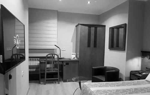 a bedroom with a bed and a desk and a chair at Idh Angel in Oviedo