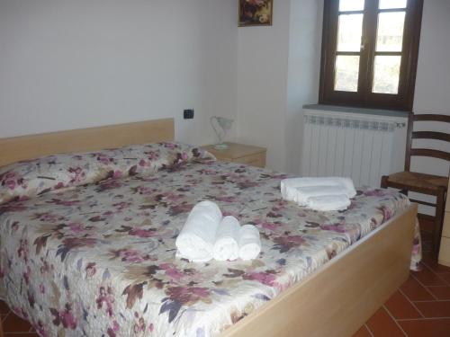 a bedroom with a bed with two towels on it at Complesso colonico Pogginano in Pelago
