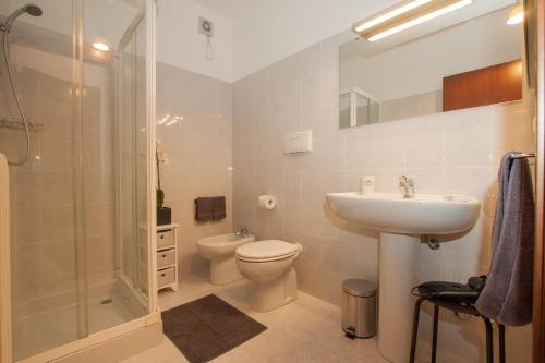 a bathroom with a toilet and a sink and a shower at Casa Gaia in Stresa
