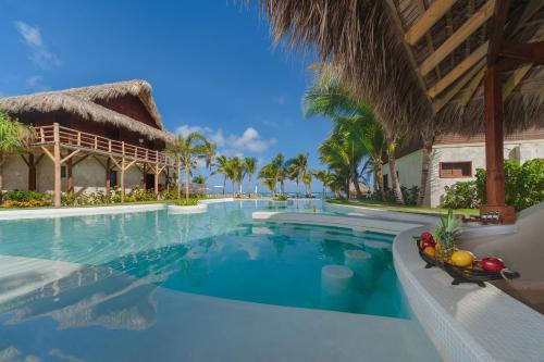 a swimming pool at a resort with palm trees at Zoetry Agua Punta Cana - All Inclusive in Punta Cana