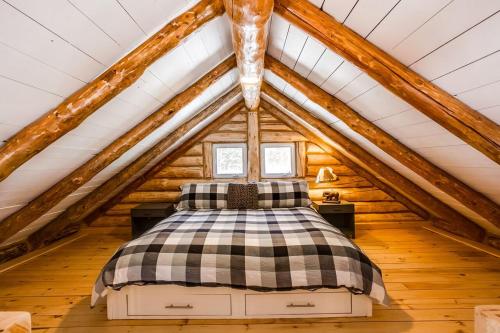 1 dormitorio con 1 cama en el ático en Le log home - Locations du sommet, en Saint Adolphe D'Howard