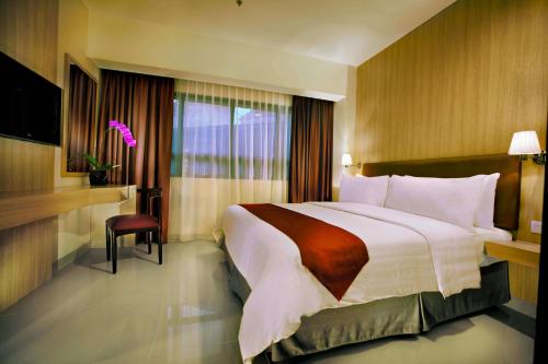 a hotel room with a large bed and a window at Atria Residences Gading Serpong in Serpong