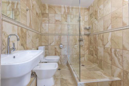 a bathroom with a sink and a toilet and a shower at SeaSide Guest Rooms in Burgas