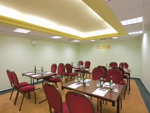 a conference room with tables and red chairs at Hotel Lövér Sopron in Sopron