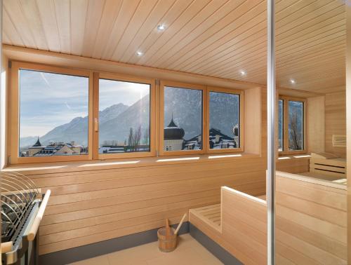 a sauna with windows and a view of a mountain at Vergeiner's Hotel Traube in Lienz