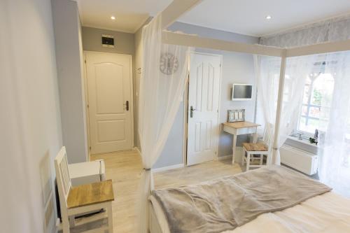 una camera da letto con un letto, una scrivania e una finestra di Villa Harmónia a Gyula