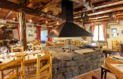 a large kitchen with a large stone stove in a restaurant at Aux 500 Diables Eco Lodge - Hotel in Chambon-sur-Lac