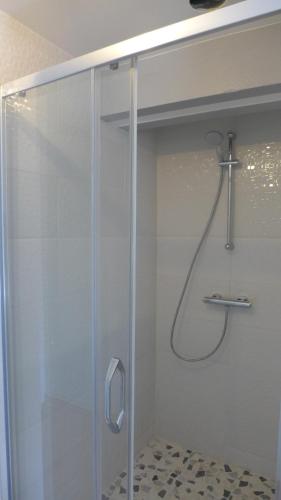 a shower with a glass door in a bathroom at Le Semoir in Bény-sur-Mer