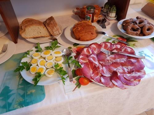 a table topped with plates of breakfast meats and eggs at B&B Barbara Assisi in Cannara